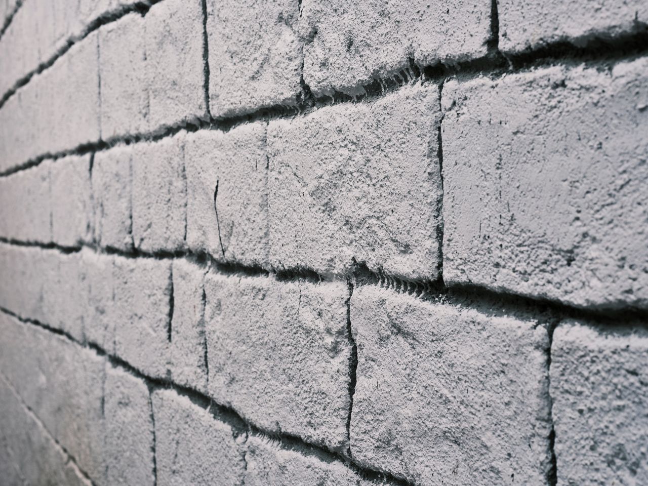 Detailed close-up of a weathered brick wall showcasing its rough texture and structure.