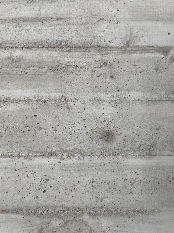 Close-up of a rough concrete texture featuring horizontal lines and gray tones for backgrounds.